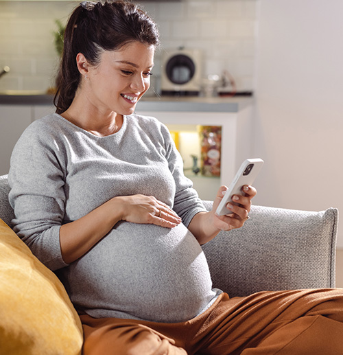 Pregnant woman using phone to count kicks
